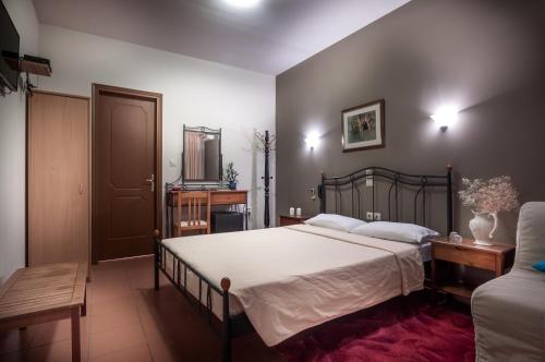 a bedroom with a large bed with white sheets at River Side Rooms in Elassona
