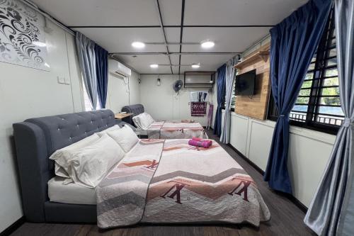 a room with two beds and a couch and a tv at Nurbayu Chalet, Kemaman in Kuantan