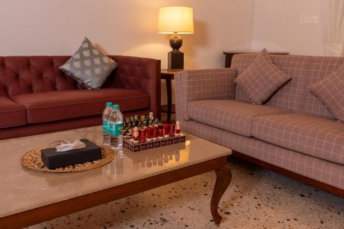 a living room with two couches and a chess board on a table at Rosastays Panjim North Goa in Goa