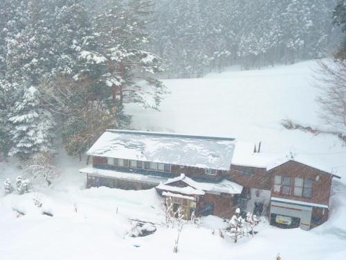 a house with snow on the roof of it at Nakanoya in Nanto