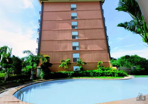 a tall building with a swimming pool in front of it at Luxury Stay with Balcony, Free Gym & Pool in Bancao-Bancao - B2 6Luster in Puerto Princesa City