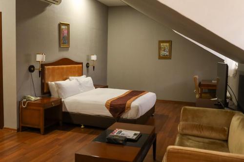 a hotel room with a bed and a living room at Sheki Palace Hotel in Sheki
