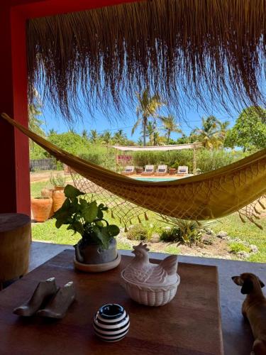 a hammock in a room with a view of a yard at Casa Vermelha in Praia do Tofo
