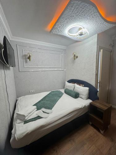 a bedroom with a bed with a green blanket on it at Pembe Köşk Old City Center in Istanbul