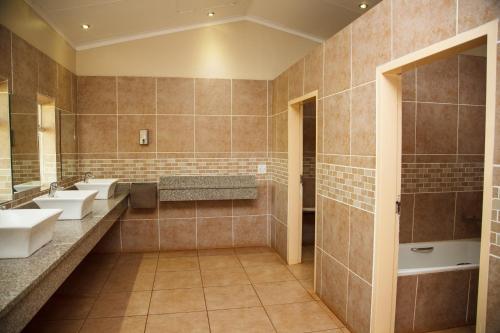 a bathroom with three sinks and two mirrors at Blyde Canyon, A Forever Resort in Matibidi
