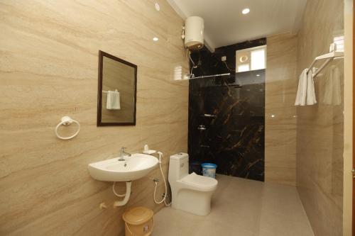 a bathroom with a sink and a toilet and a shower at Janz Marina Bay in Puducherry
