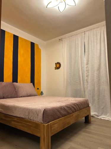 a bedroom with a bed with a yellow and blue wall at Panorama in Someraro