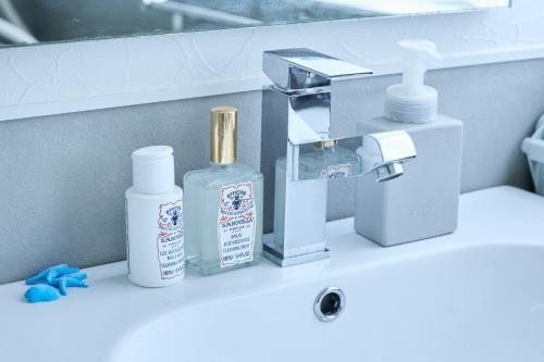 a bathroom sink with hygiene products on a counter at Chez Wataamé99 in Chosei