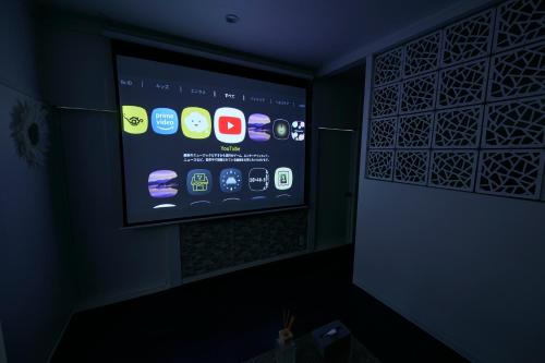 a room with a projection screen in a dark room at Chez Wataamé99 in Chosei