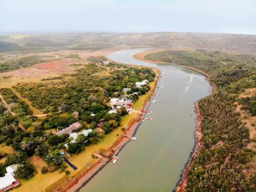 an aerial view of a river with houses and trees at Coelacanth Sea & River Lodge in Kayserʼs Beach