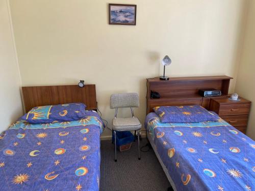 a bedroom with two beds and a desk and a chair at Sea Mist 7 Strangways Tce Port Elliot in Port Elliot