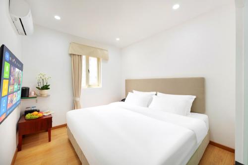 a bedroom with a large white bed and a television at Guang Yun Hotel Guangzhou in Guangzhou