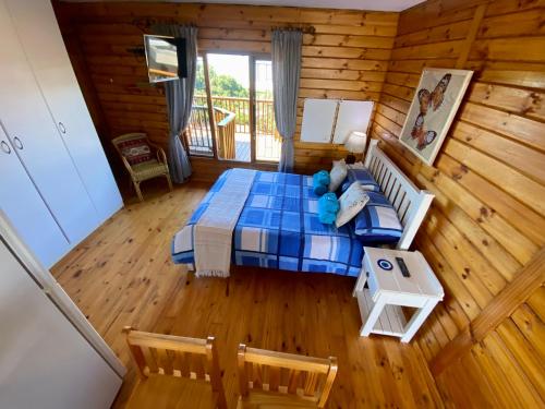 a bedroom with a bed in a log cabin at Shore Enuff - Ocean and Garden View in Jeffreys Bay