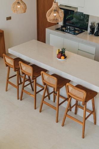 a kitchen with a table and chairs with a bowl of fruit at 2BR Ricefield View Villa in Munggu Easy Beach Access in Munggu