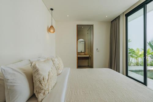 a bedroom with a white bed and a large window at 2BR Ricefield View Villa in Munggu Easy Beach Access in Munggu