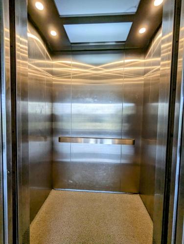 a elevator in a building with a metal wall at Luxurious Apartment at Banani in Dhaka