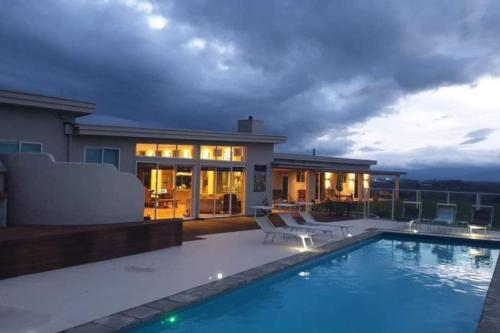 a house with a swimming pool in front of a house at Chagall Suite in an 6-bedroom luxury villa in Blenheim