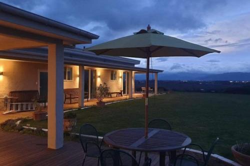 a patio with a table and an umbrella at Chagall Suite in an 6-bedroom luxury villa in Blenheim