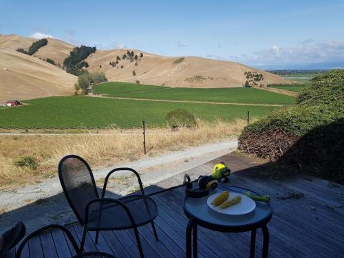 a table with a plate of food and chairs on a porch at Chagall Suite in an 6-bedroom luxury villa in Blenheim