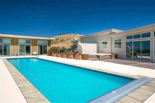 a swimming pool in front of a house at Cloudy Bay Suite in an 6-bedroom luxury villa in Blenheim