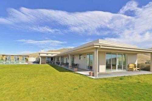 a large house with a large lawn in front of it at Cloudy Bay Suite in an 6-bedroom luxury villa in Blenheim