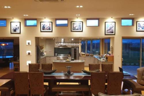 a dining room with a table and chairs and a kitchen at Cloudy Bay Suite in an 6-bedroom luxury villa in Blenheim