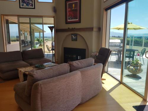 a living room with a couch and a fireplace at Cloudy Bay Suite in an 6-bedroom luxury villa in Blenheim