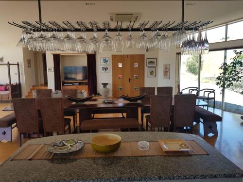 a dining room with a table and chairs and glasses at Cloudy Bay Suite in an 6-bedroom luxury villa in Blenheim