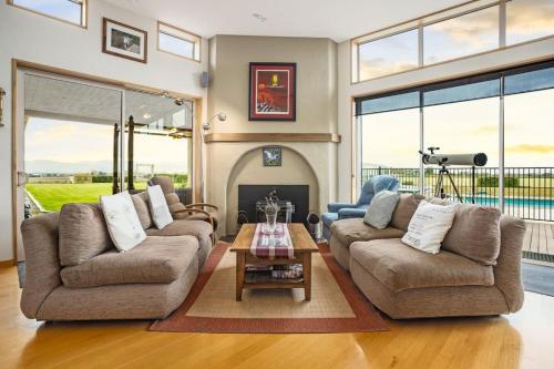 a living room with two couches and a table at Cloudy Bay Suite in an 6-bedroom luxury villa in Blenheim