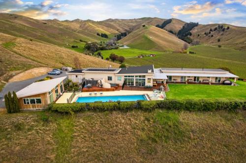 an aerial view of a house in a hill with a pool at Cloudy Bay Suite in an 6-bedroom luxury villa in Blenheim