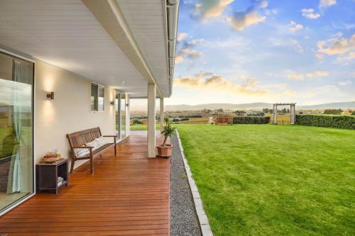 a porch of a house with a green lawn at Cloudy Bay Suite in an 6-bedroom luxury villa in Blenheim