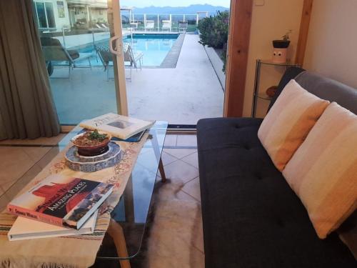 a living room with a table and a couch and a pool at Oceanview Suite in an 6-bedroom luxury villa in Blenheim