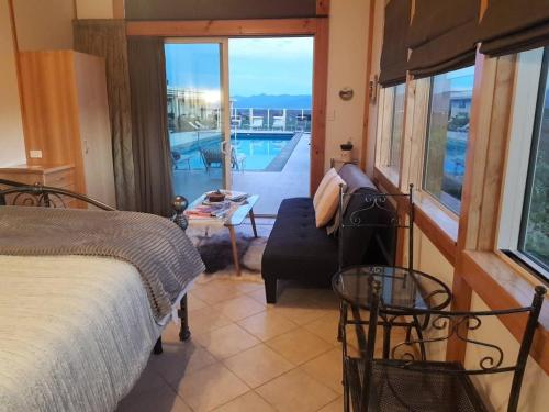 a bedroom with a bed and a view of a pool at Oceanview Suite in an 6-bedroom luxury villa in Blenheim