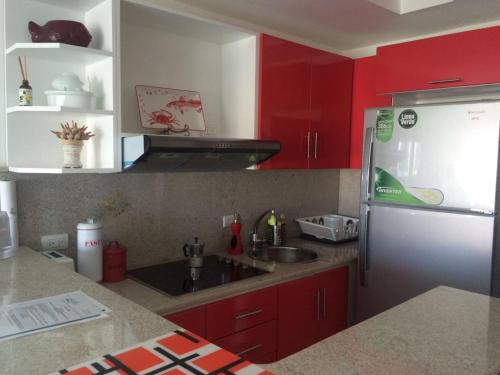 a kitchen with red cabinets and a stainless steel refrigerator at Vista Marina Residence in Boca Chica