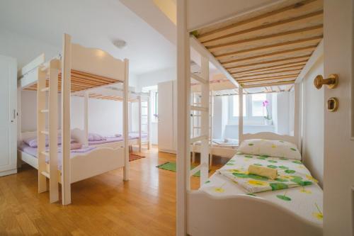 two bunk beds in a room with wooden floors at Hostel Marinero in Hvar