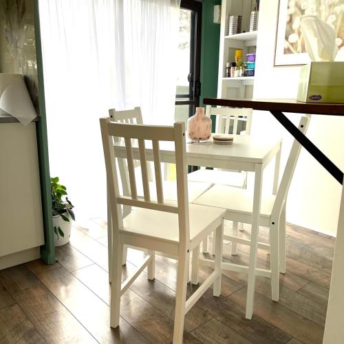 a white table and chairs next to a white table and bench at Serendipity Cottage Farm Stay in Jeremadra
