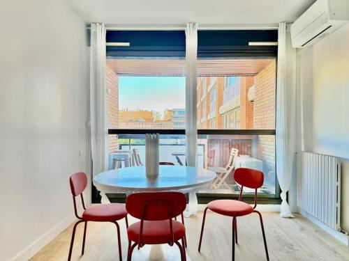 une salle à manger avec une table et des chaises et une grande fenêtre dans l'établissement Darius by Yumē, à Toulouse