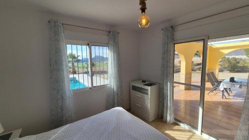 a bedroom with a bed and a view of a patio at Casa Cocon in Águilas