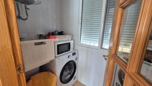 a laundry room with a washing machine and a washer at Casa Cocon in Águilas