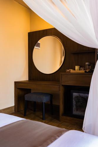 a bedroom with a mirror and a chair next to a fireplace at Shankara Munduk Bali in Munduk