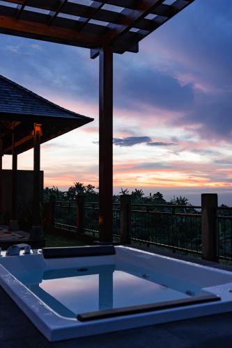 a hot tub on a patio with a sunset at Shankara Munduk Bali in Munduk