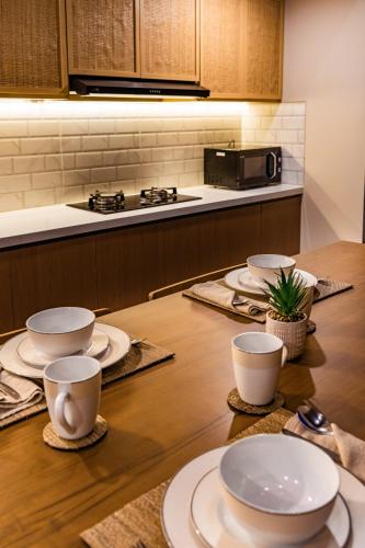 a kitchen with a wooden table with plates and cups at Shankara Munduk Bali in Munduk
