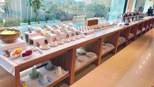 a buffet line with bowls and plates on display at All-Ur Boutique Motel - KaoHsiung Branch in Kaohsiung