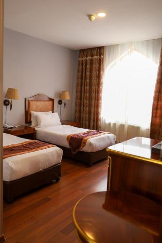 a hotel room with two beds and a window at Sheki Palace Hotel in Sheki