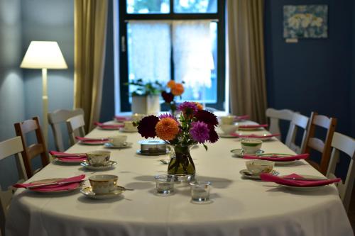a long table with a vase of flowers on it at Sophienhof Neu Heinde in Prebberede