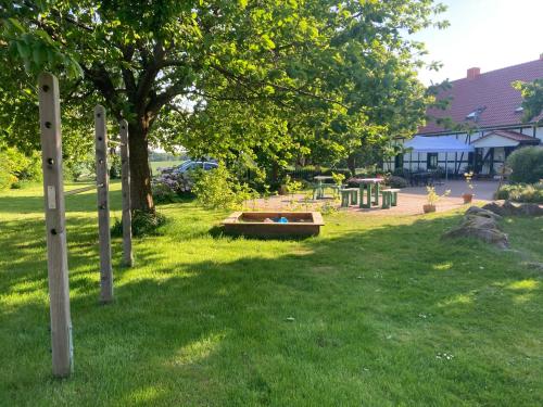 a park with a tree and a bench in the grass at Sophienhof Neu Heinde in Prebberede