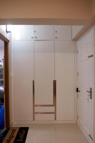 a closet with white cabinets and a glass door at Luxairy in Chewarra