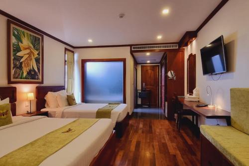 a hotel room with two beds and a flat screen tv at Maison Saiko Angkor Boutique in Siem Reap