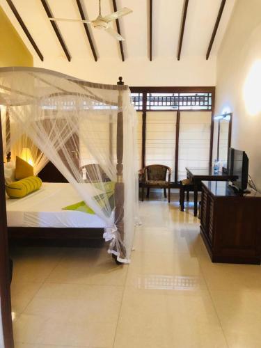 a bedroom with a bed with a mosquito net at Wet Water Airport Resort in Gampaha