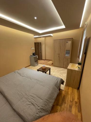 ein Schlafzimmer mit einem großen Bett und einem Tisch in der Unterkunft Sondos Al-Arbia in Riad